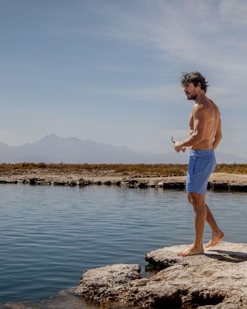 Pré-Summer Sardegna: homem de short de banho azul à beira de uma lagoa